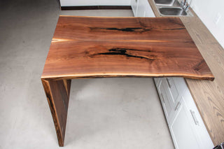 bar height bookmatch waterfall table in walnut attached to a counter