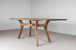 modern style walnut table in squoval shape on walnut legs