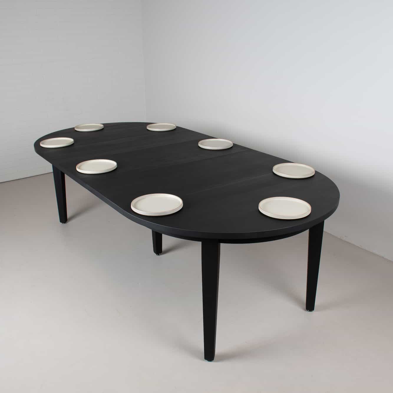 round extendable table finished in black on modified parsons base