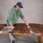 person adding a leaf to a round extendable table