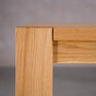 corner of an Estling base of an extendable Oak Parsons table  finished in Pure D 