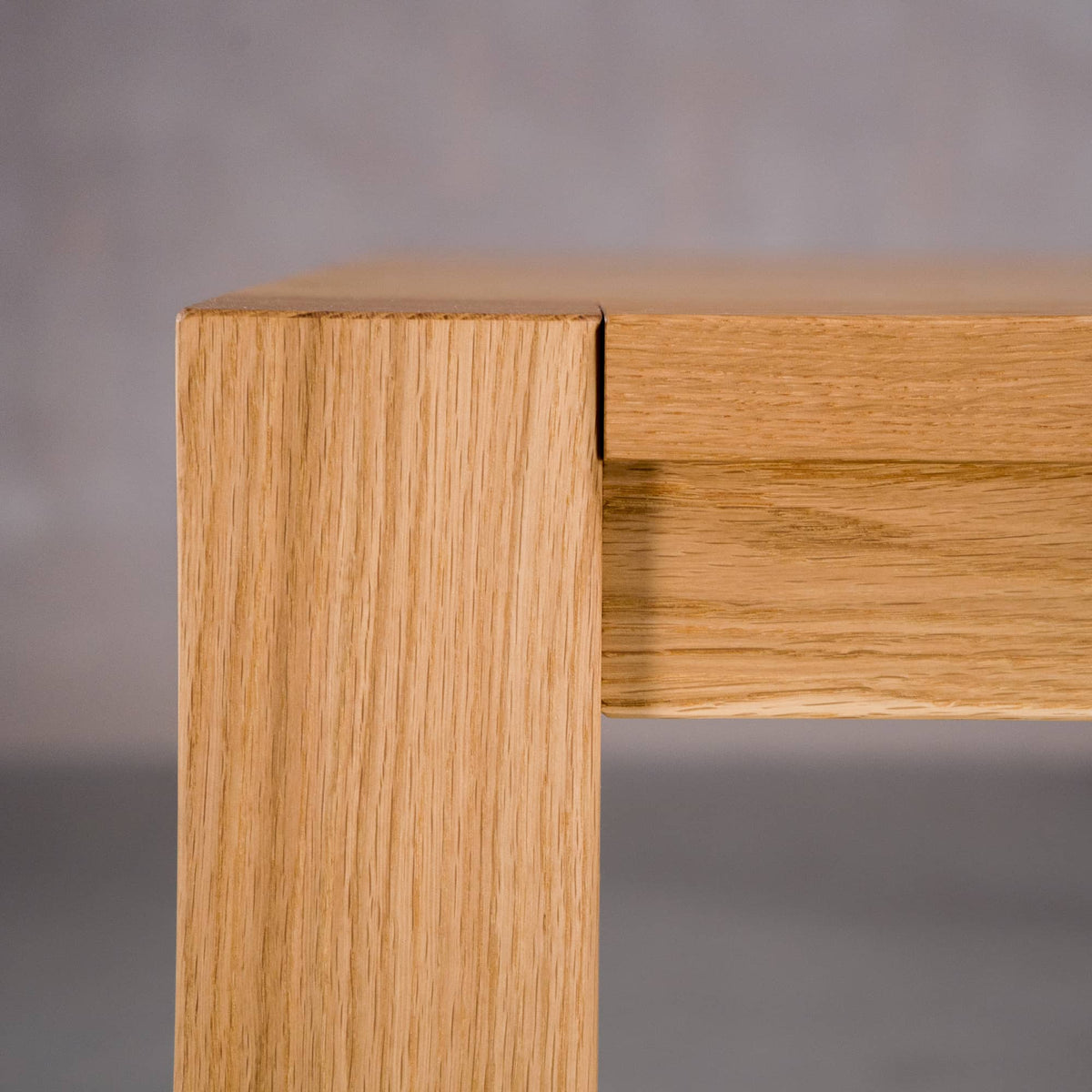 corner of an Estling base of an extendable Oak Parsons table  finished in Pure D 