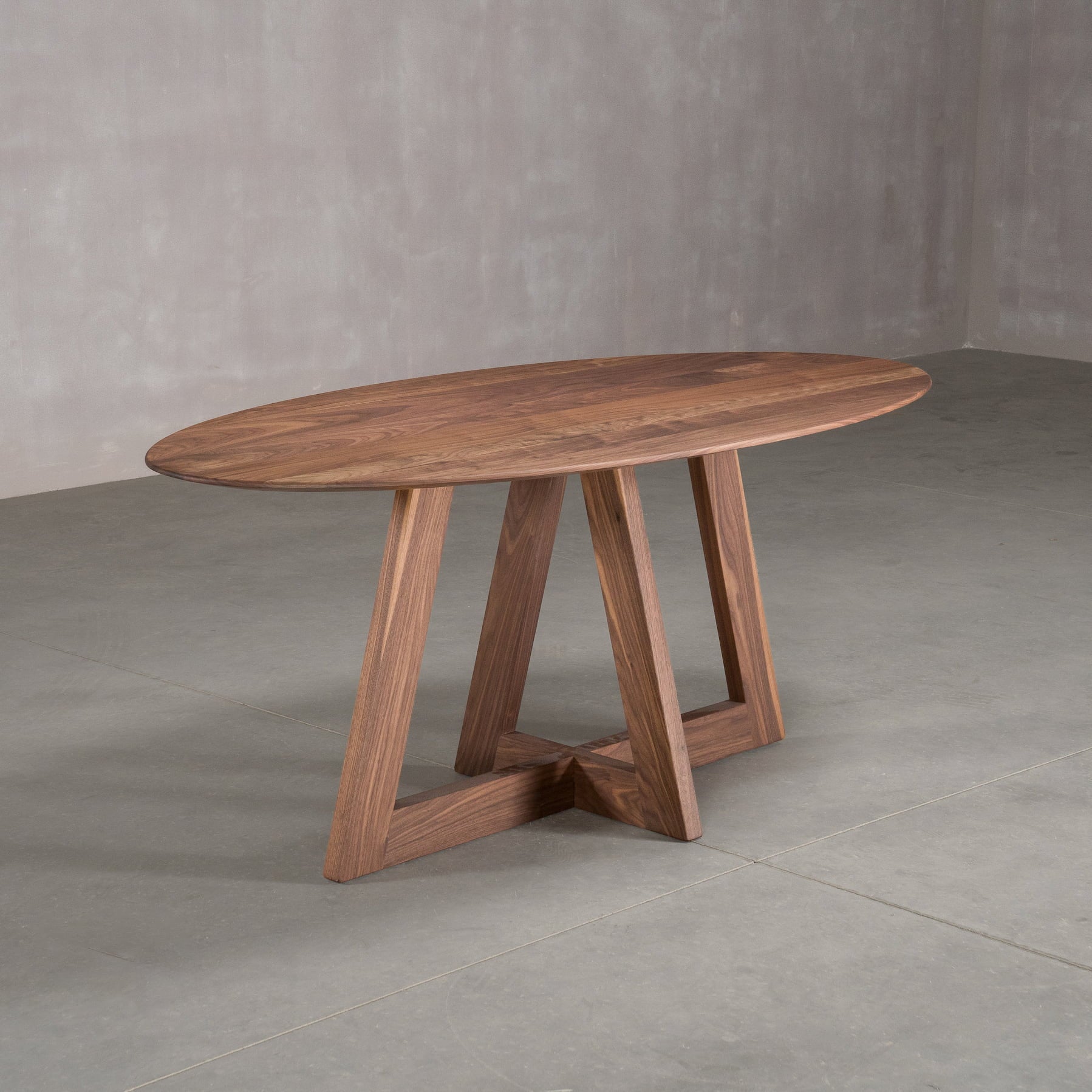 elliptical Walnut table 36” wide x 72” long, finished in Pure D on Moraine base