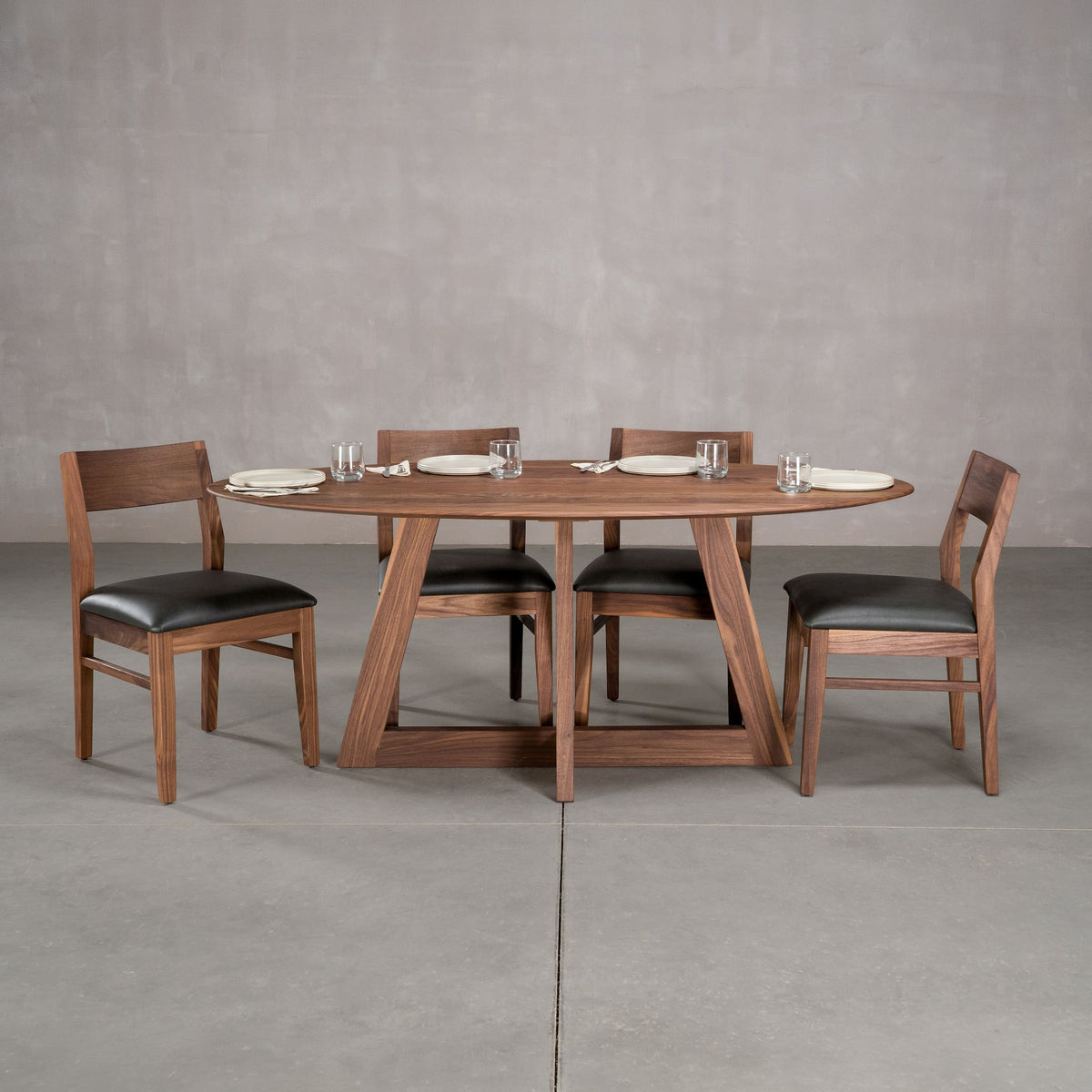 elliptical Walnut table 36” wide x 72” long, finished in Pure D on Moraine base; shown with Walnut Aubrey chairs
