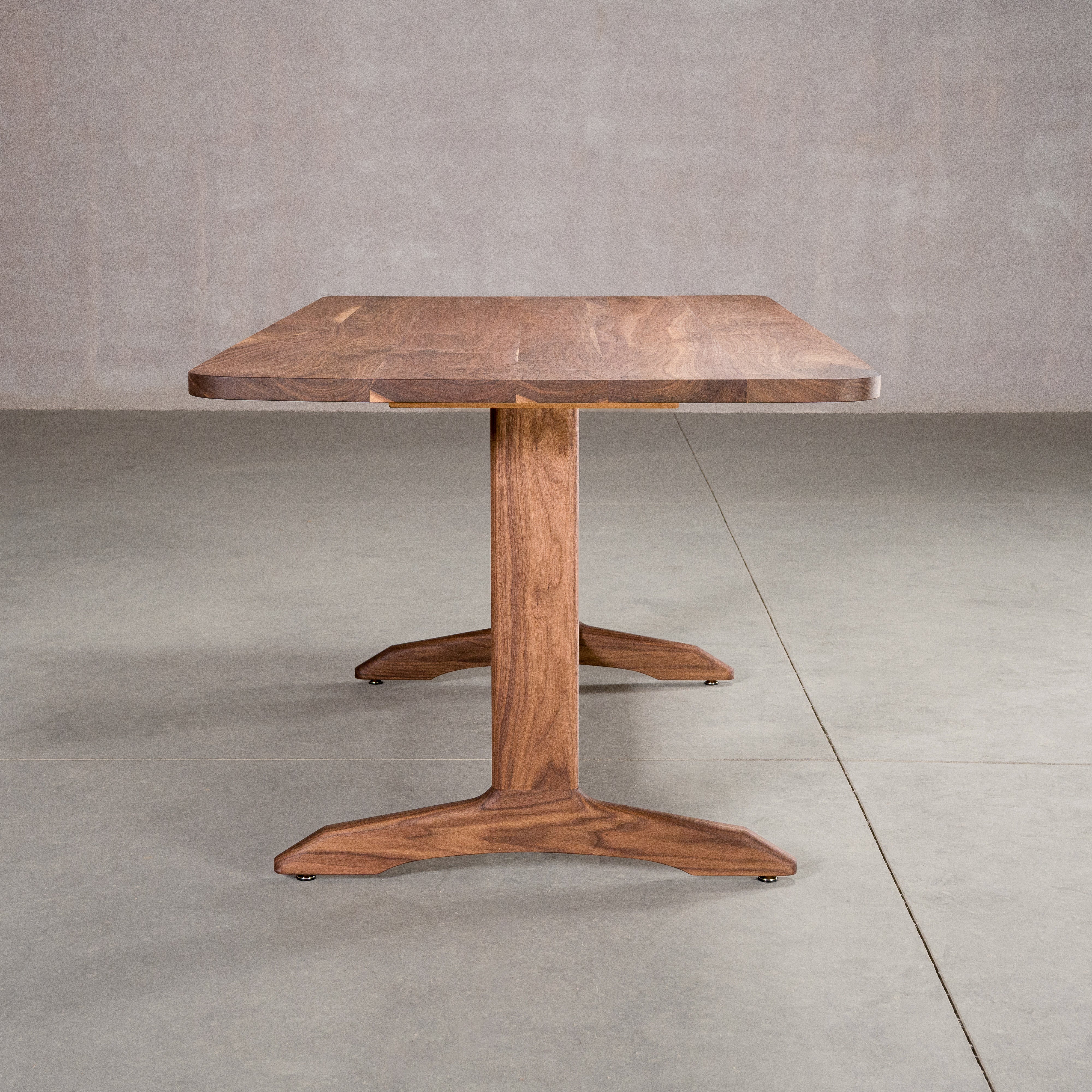 end view of rectangle Walnut table 36” wide x 72” long, finished in Pure D on Tobin trestle base