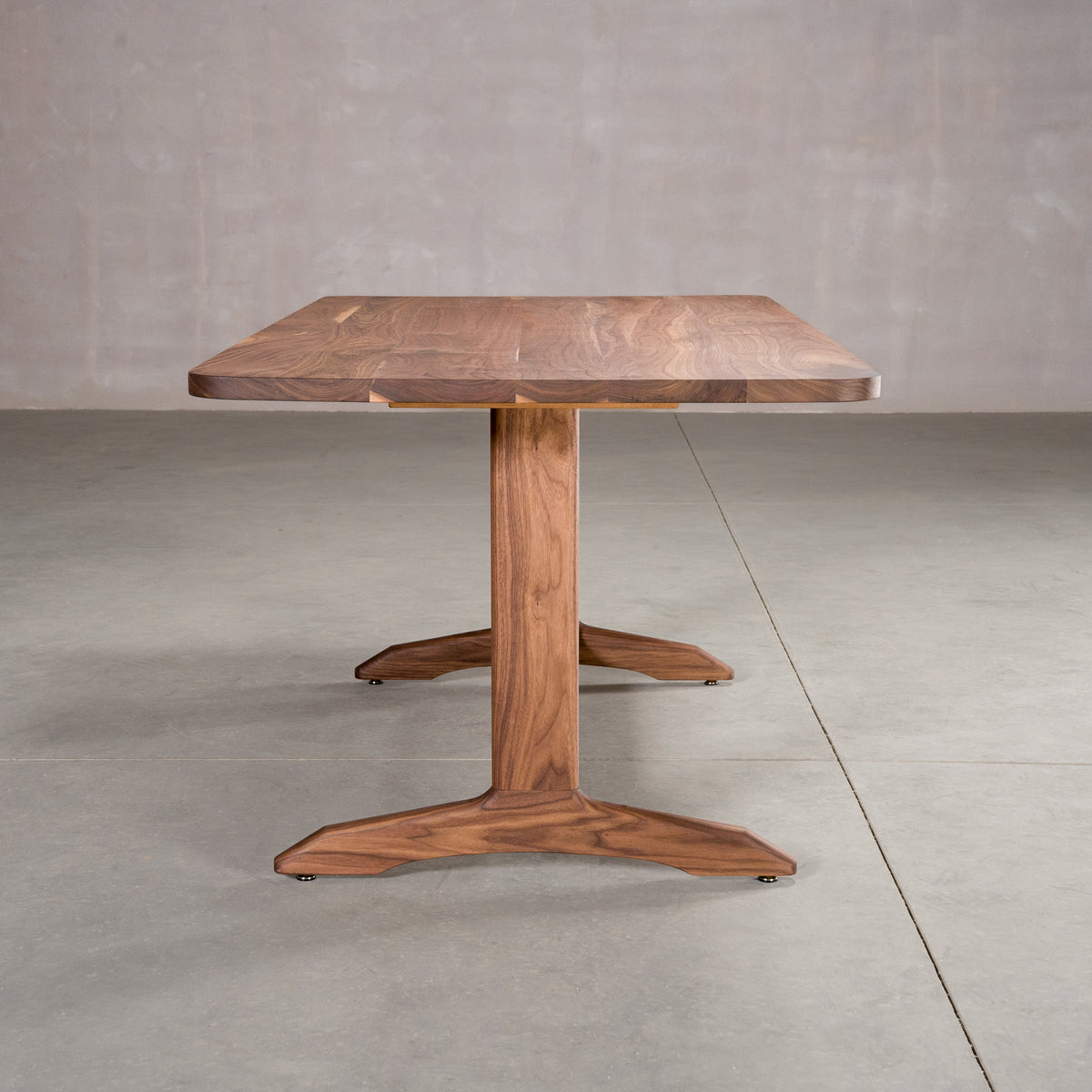 end view of rectangle Walnut table 36” wide x 72” long, finished in Pure D on Tobin trestle base