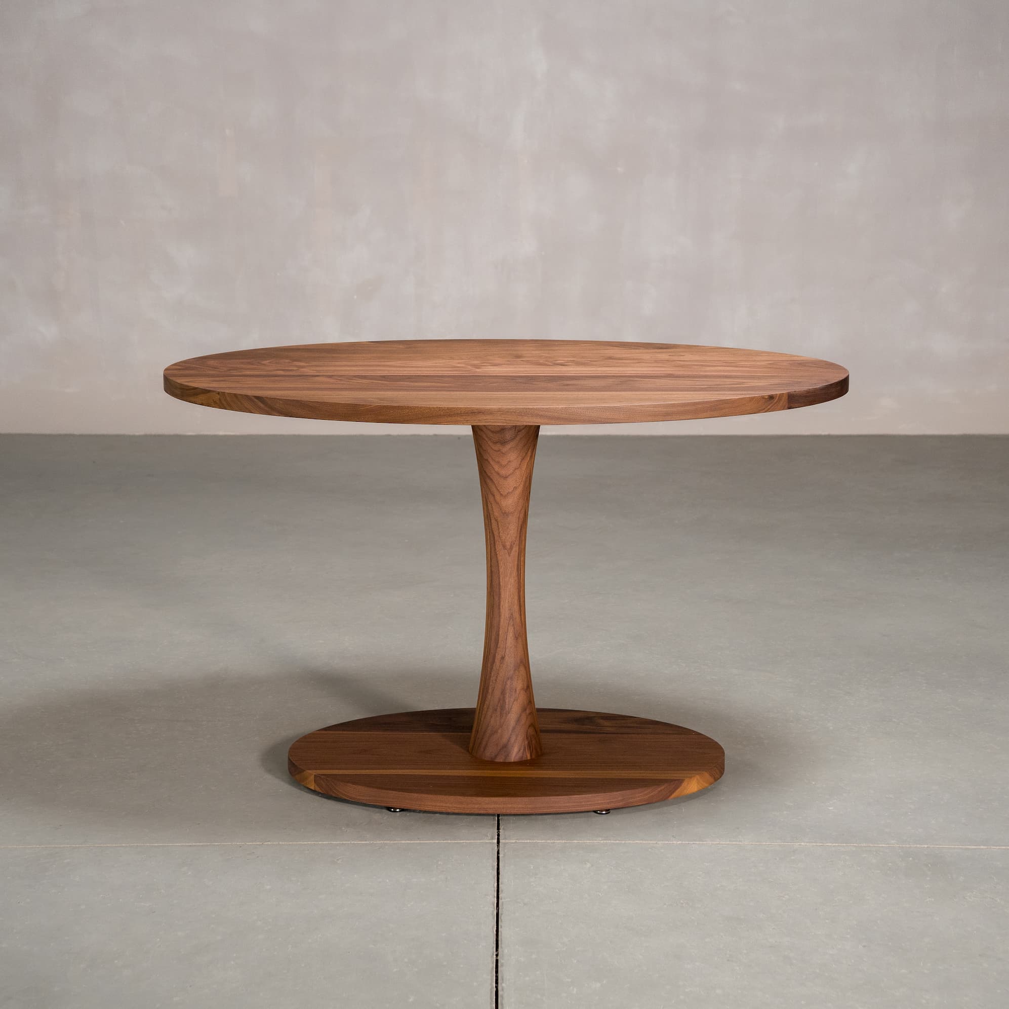 elliptical Walnut table 30” wide x 48” long, finished in Pure D on a Jennings pedestal base