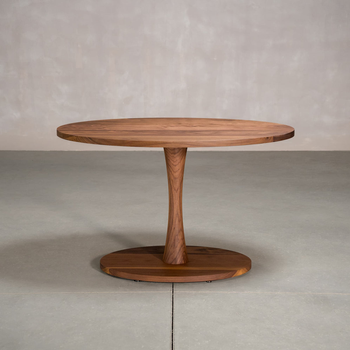 elliptical Walnut table 30” wide x 48” long, finished in Pure D on a Jennings pedestal base