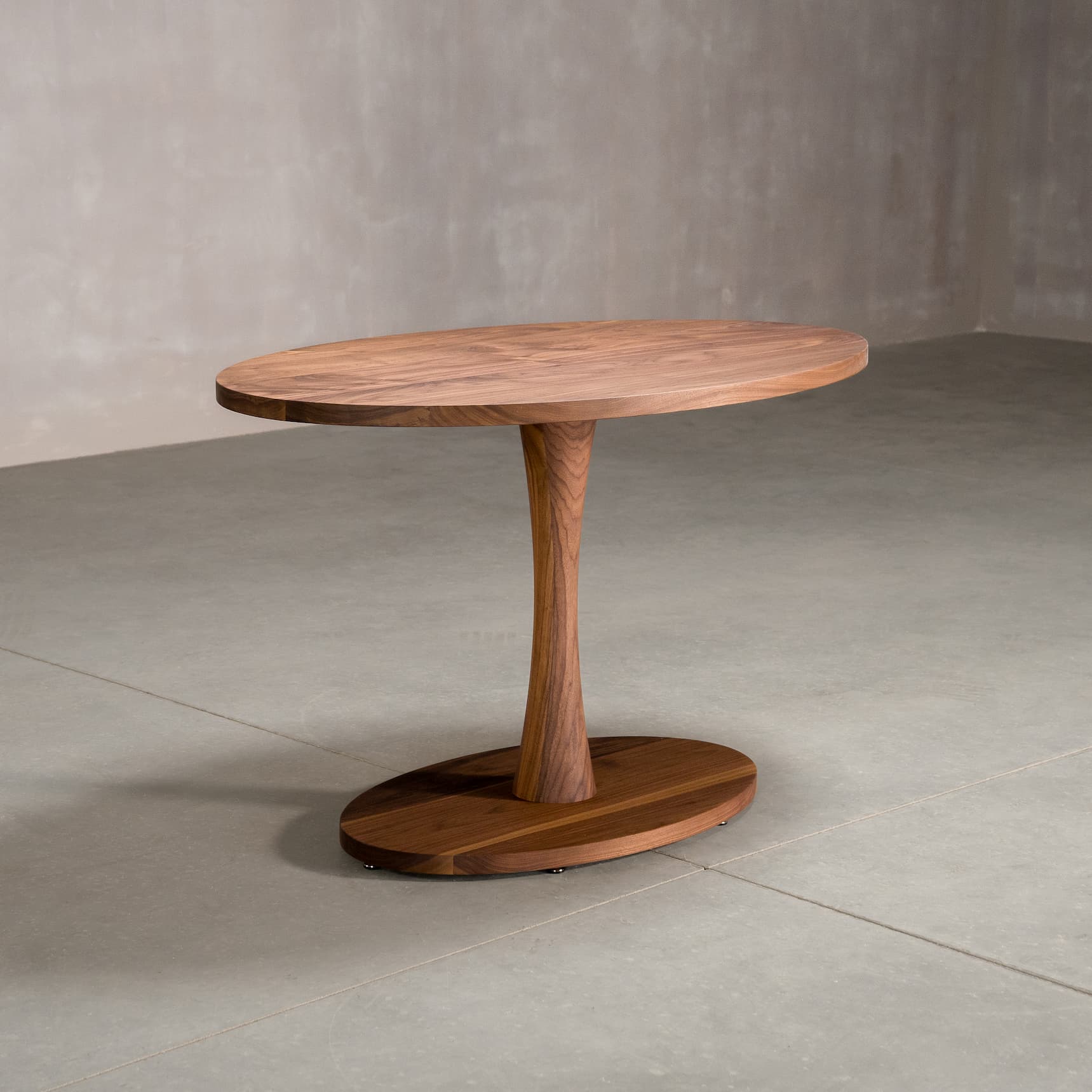 elliptical Walnut table 30” wide x 48” long, finished in Pure D on a Jennings pedestal base