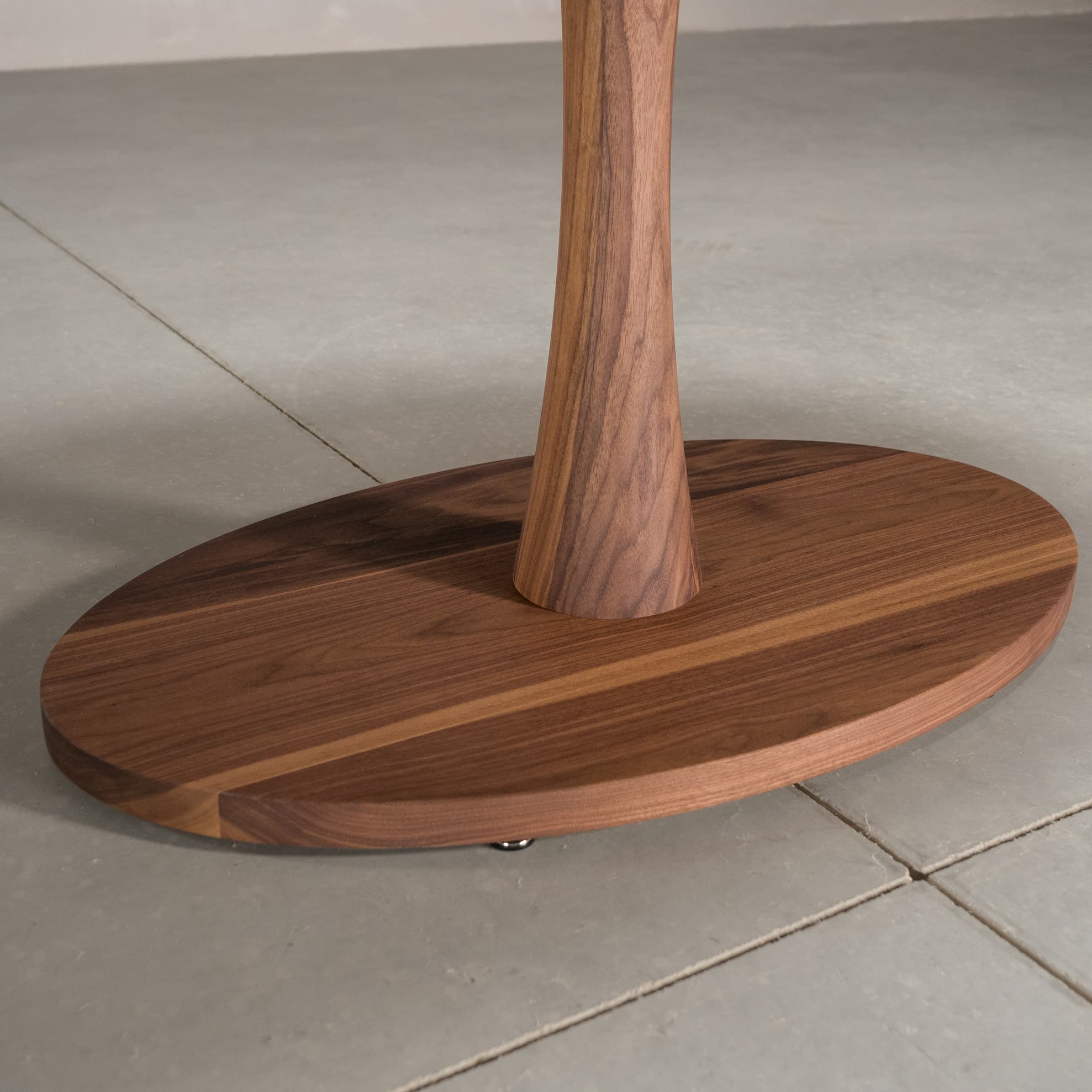 close up of the Jennings pedestal base on an elliptical Walnut table finished in Pure D 