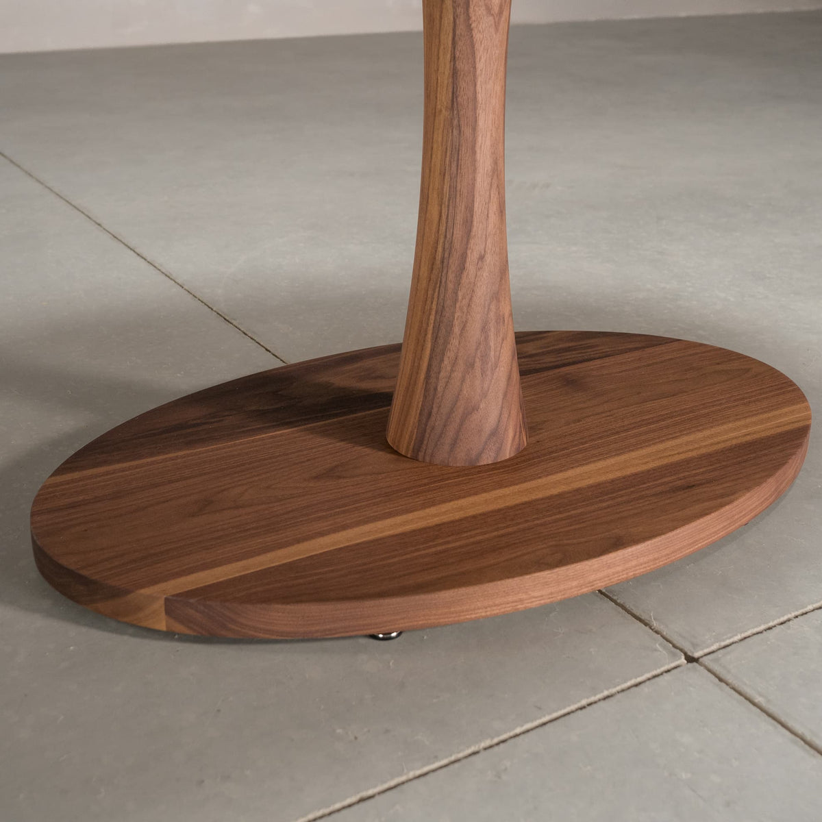 close up of the Jennings pedestal base on an elliptical Walnut table finished in Pure D 