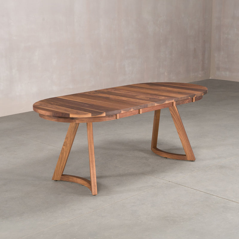 oval extendable Walnut table 36” wide x 60” long, with 2-18” leaves finished in Pure D on Chesbro legs