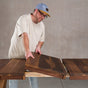 person adding a leaf to an oval extendable Walnut table 36” wide x 60” long, with 2-18” leaves finished in Pure D 