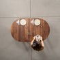 person setting an oval extendable Walnut table 36” wide x 60” long, finished in Pure D