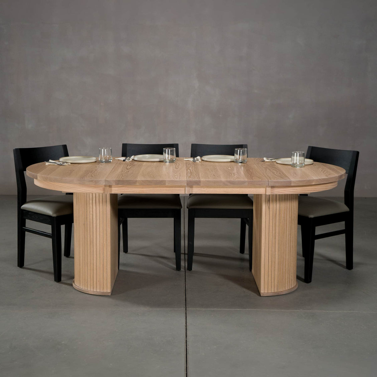 round extendable White Oak table 42” wide x 42” long, with 2-18” leaves finished in Clear D on Split Como base shown with Aubrey chairs