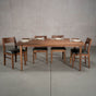 rectangular Walnut table 42” wide x 72” long, finished in Pure D on Milford base; shown with Aubrey chairs
