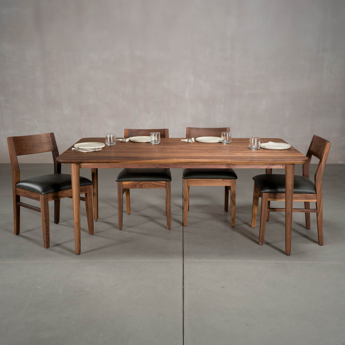 rectangular Walnut table 42” wide x 72” long, finished in Pure D on Milford base; shown with Aubrey chairs
