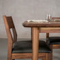 seating at the end of a rectangular Walnut table finished in Pure D on Milford base
