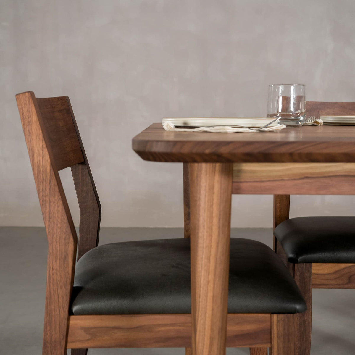 seating at the end of a rectangular Walnut table finished in Pure D on Milford base
