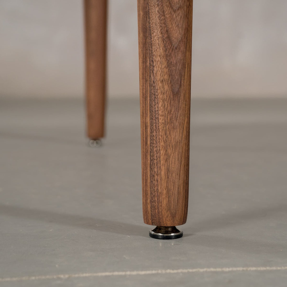 leg detail on a Milford base on a rectangular Walnut table finished in Pure D 
