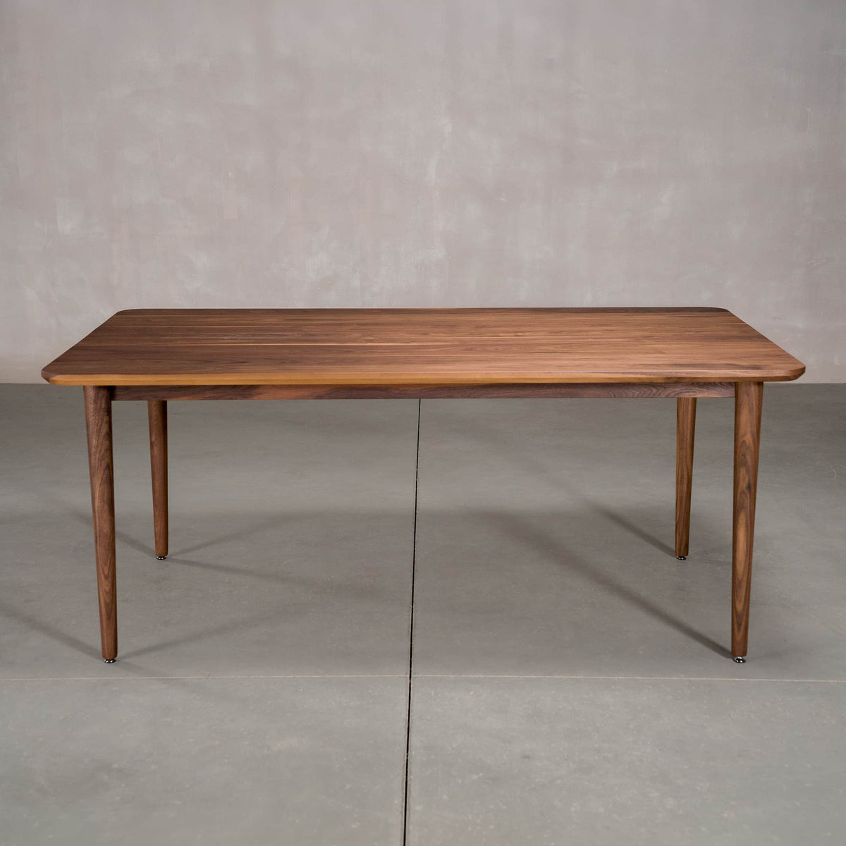 rectangular Walnut table 42” wide x 72” long, finished in Pure D on Milford base
