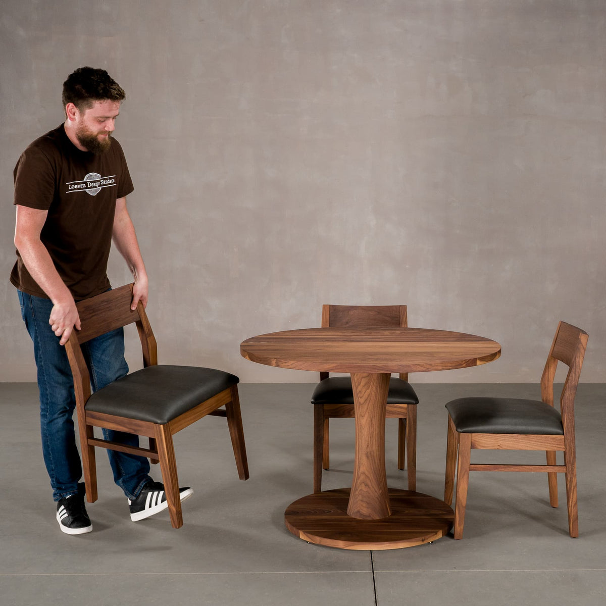 round Walnut table 42” wide x 42” long, finished in Pure D on Jennings pedestal base; shown with Aubrey chairs