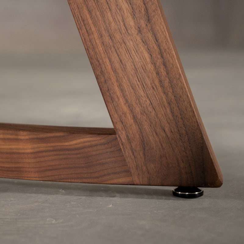 the corner of a Chesbro leg on a round  Walnut table finished in Pure D