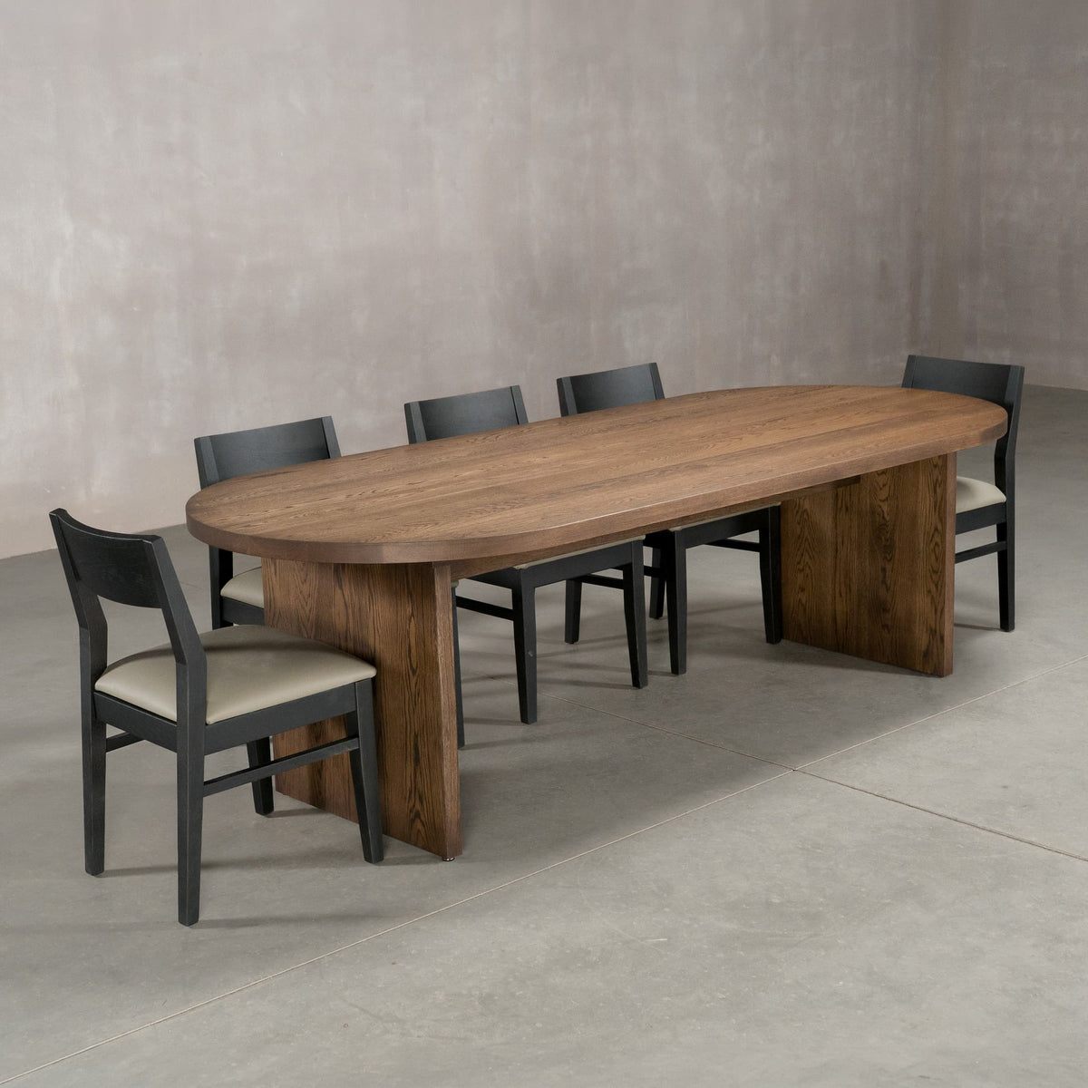 racetrack oval White Oak table 42” wide x 100” long, finished in Dark Roast D on Panuke Trestle base; shown with Aubrey chairs