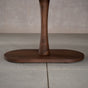 close up of the Jennings pedestal base on an oval Walnut table finished in Cortado D