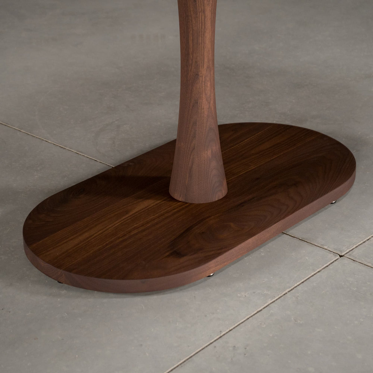 close up of the Jennings base on an oval Walnut table finished in Cortado D 