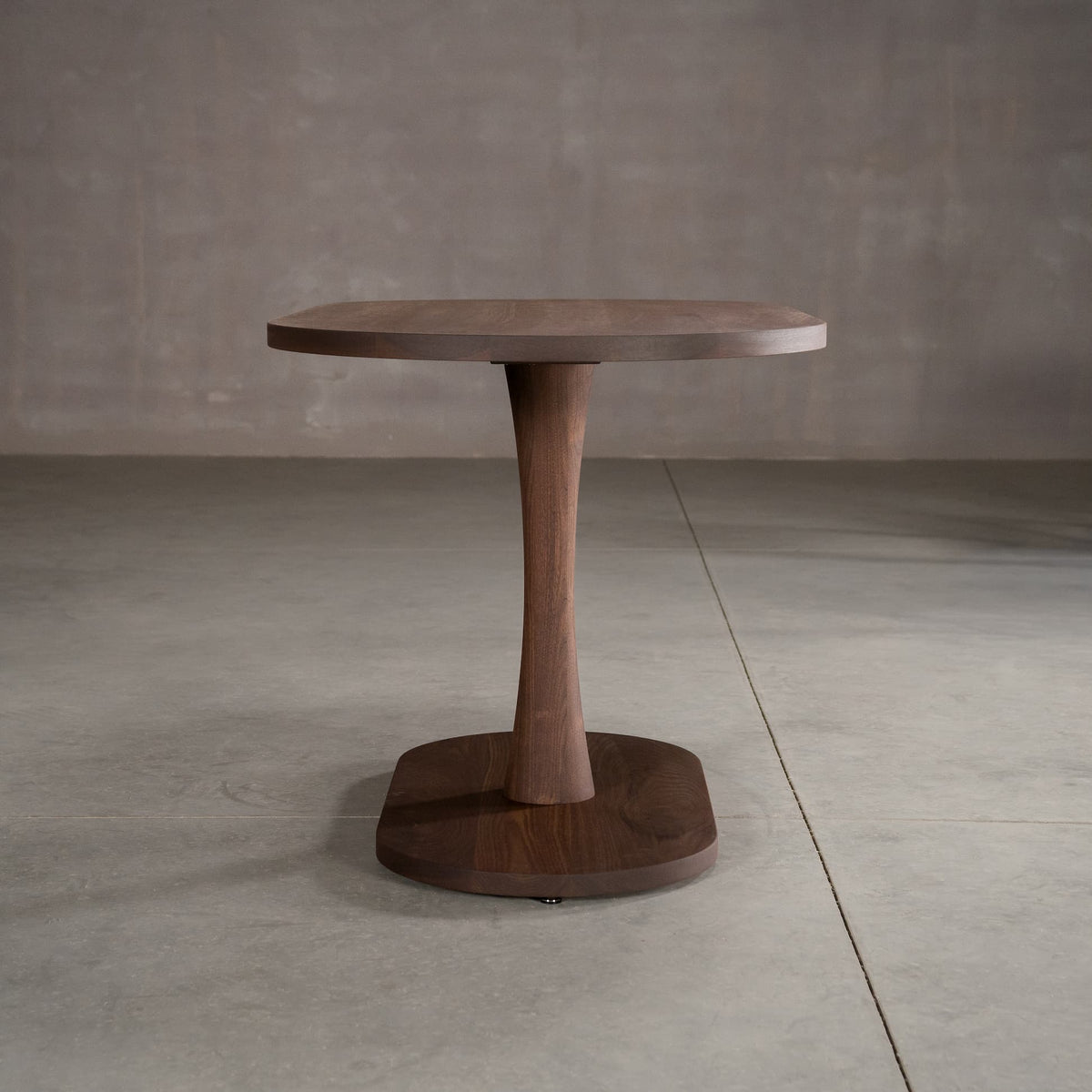 oval Walnut table 29” wide x 55” long, finished in Cortado D on a Jennings pedestal base