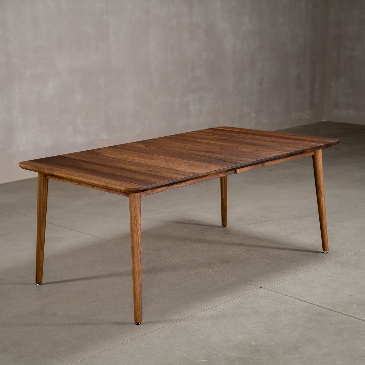 extendable Walnut table 42” wide x 72” long, with 1-18” leaf finished in Pure D on Milford base