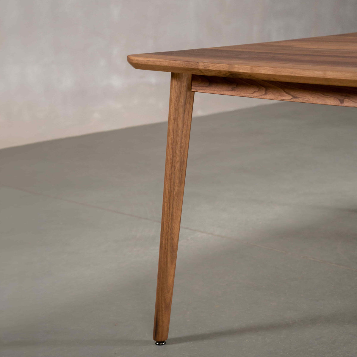 corner detail of a extendable Walnut table finished in Pure D on Milford base