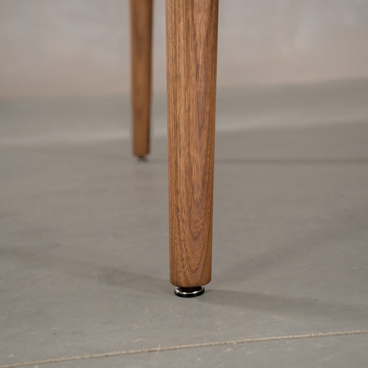 the tapered leg of a MIlford base in Walnut finished in Pure D