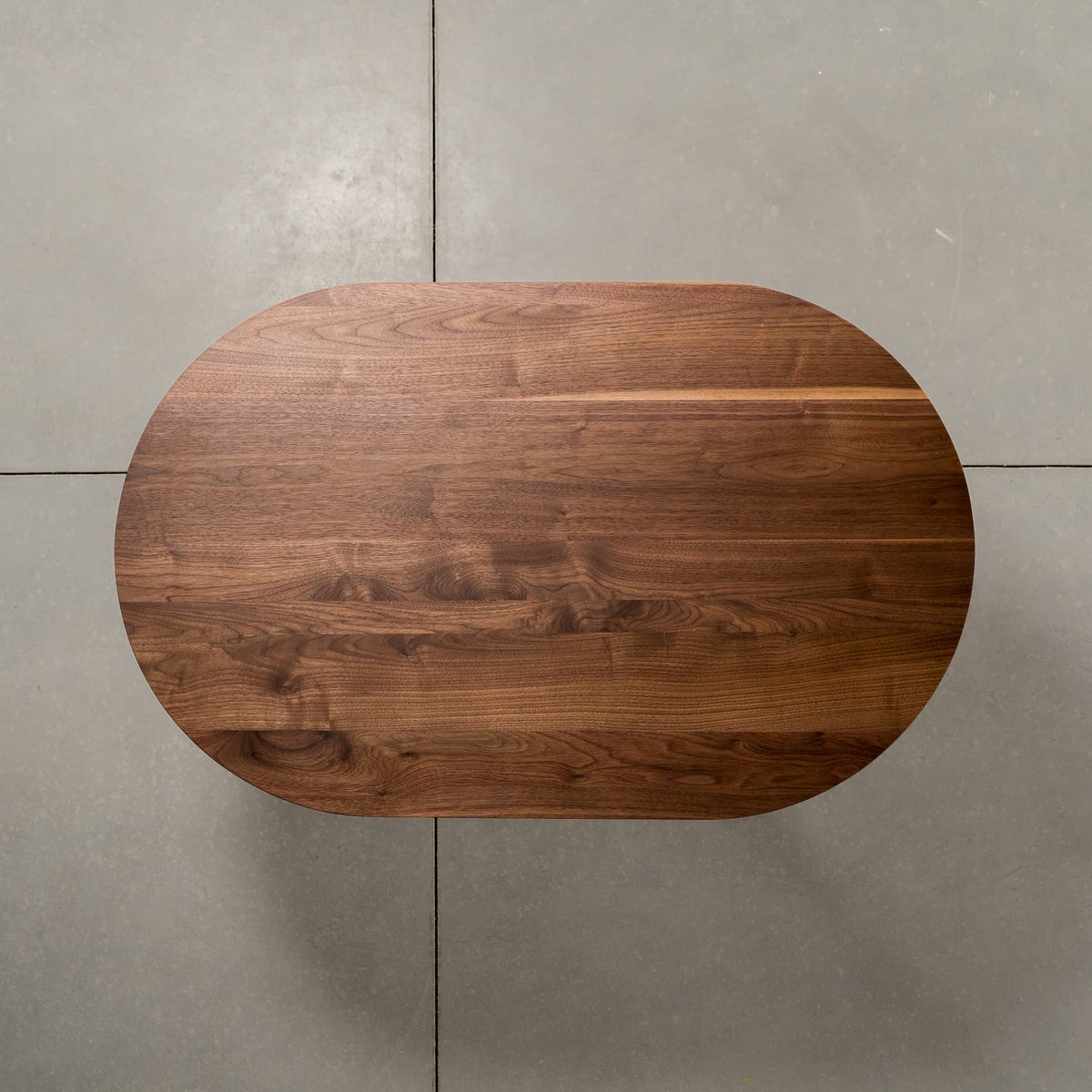 overhead view of an oval Walnut table 30” wide x 48” long, finished in Pure D 