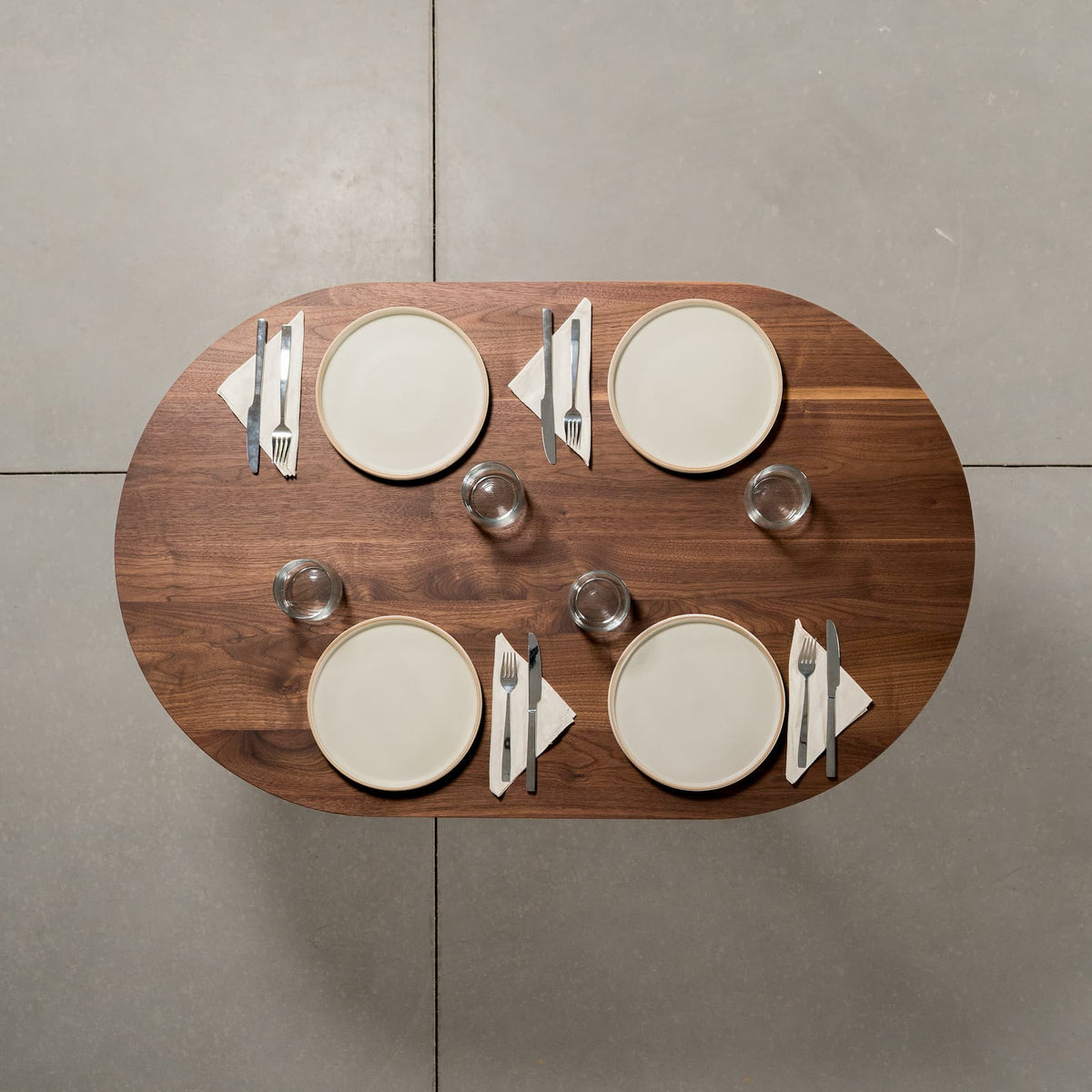 seating for 4 at an oval Walnut table 30” wide x 48” long, finished in Pure D 