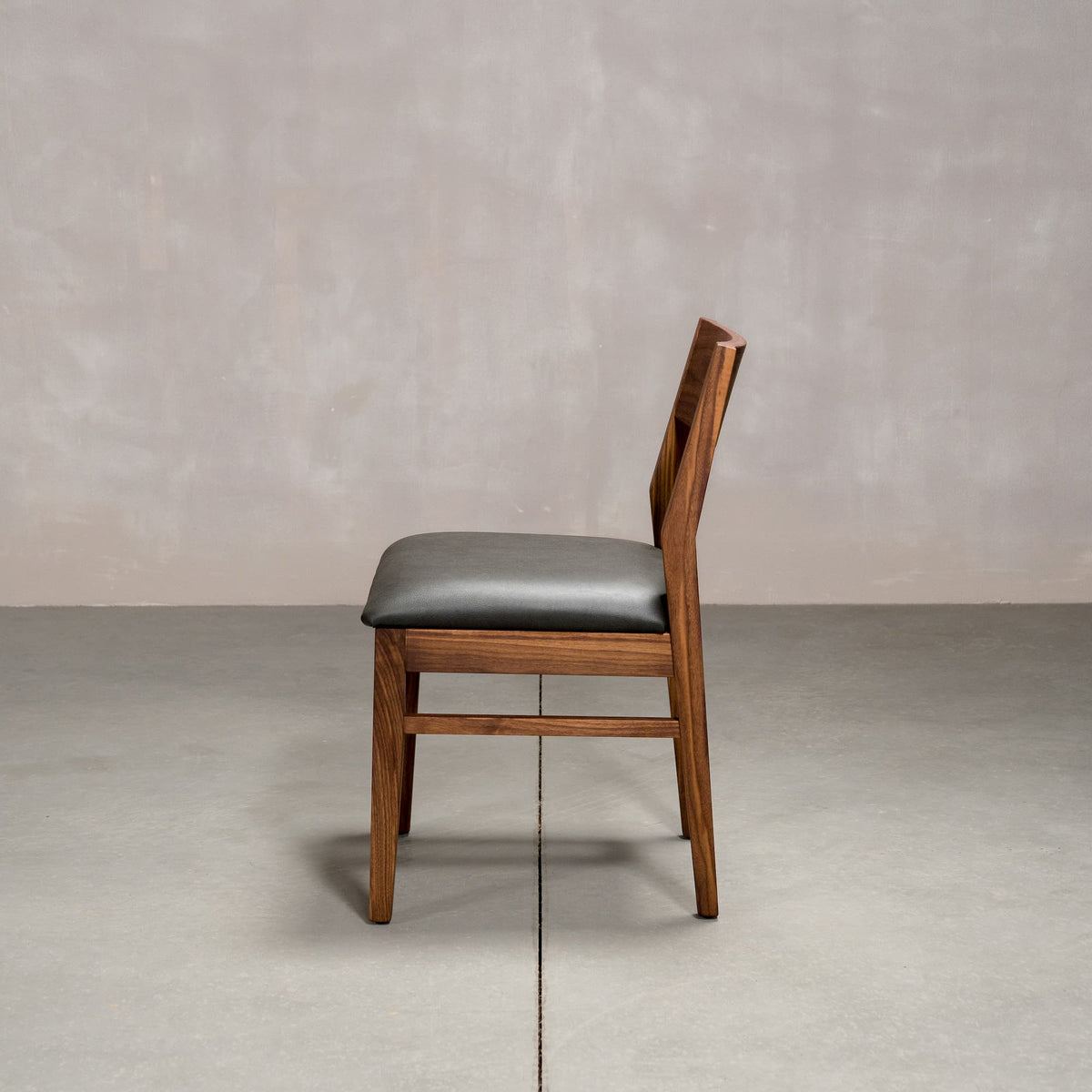 an Aubrey side chair in Walnut with a Thunder Leather seat