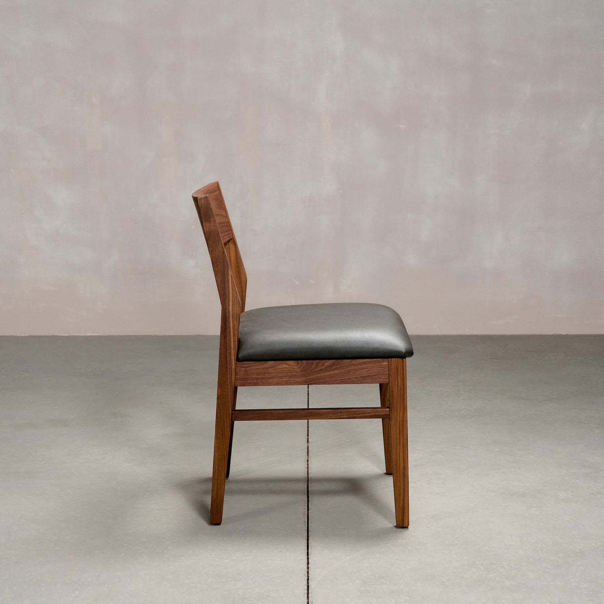 an Aubrey side chair in Walnut with a Thunder Leather seat
