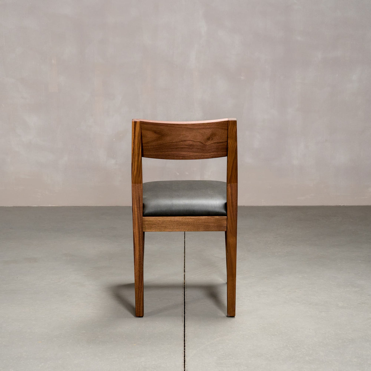 an Aubrey side chair in Walnut with a Thunder Leather seat