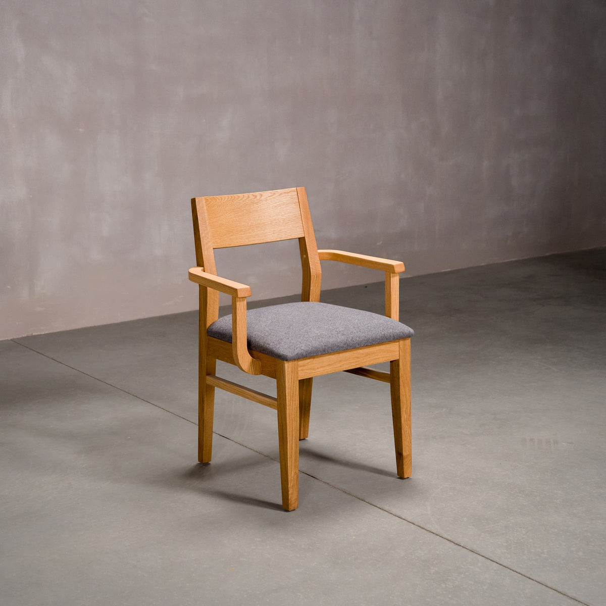 a White Oak Aubrey Armchair finished in Pure D with Graphite fabric seat