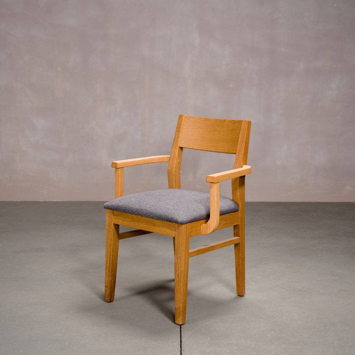 a White Oak Aubrey Armchair finished in Pure D with Graphite fabric seat