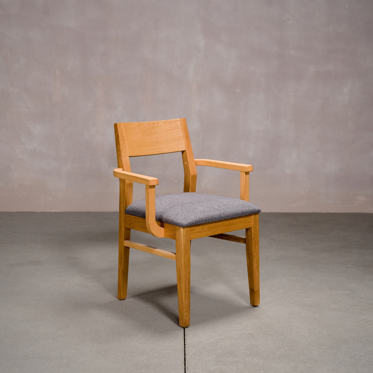 a White Oak Aubrey Armchair finished in Pure D with Graphite fabric seat