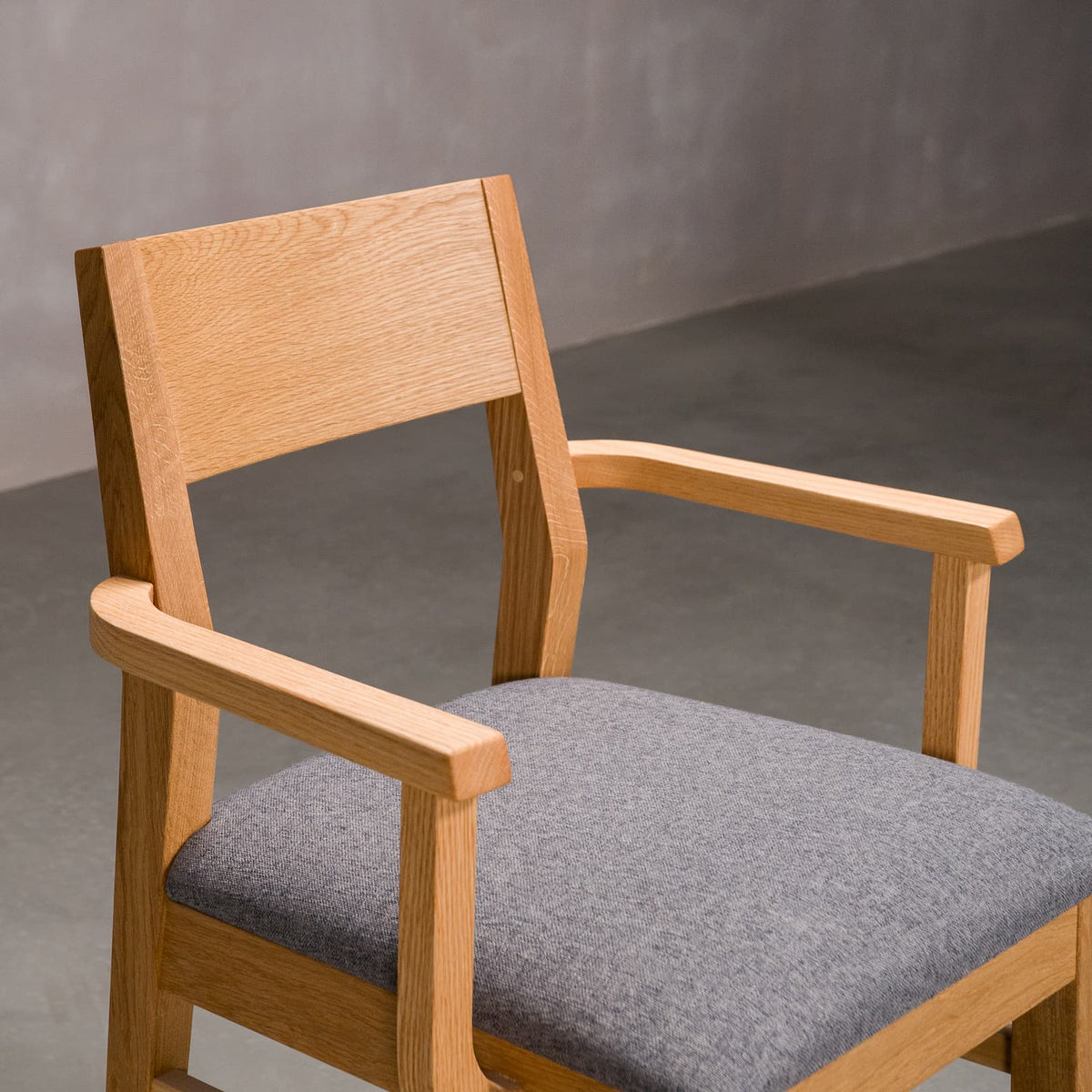seat detail of a White Oak Aubrey Armchair finished in Pure D with Graphite fabric seat