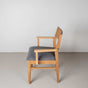 Oak dining chair with arms finished in Pure D shown with a gray fabric seat