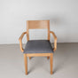 Oak dining chair with arms finished in Pure D shown with a gray fabric seat