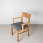 Oak dining chair with arms finished in Pure D shown with a gray fabric seat