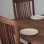 detail of high back walnut dining chairs at a table