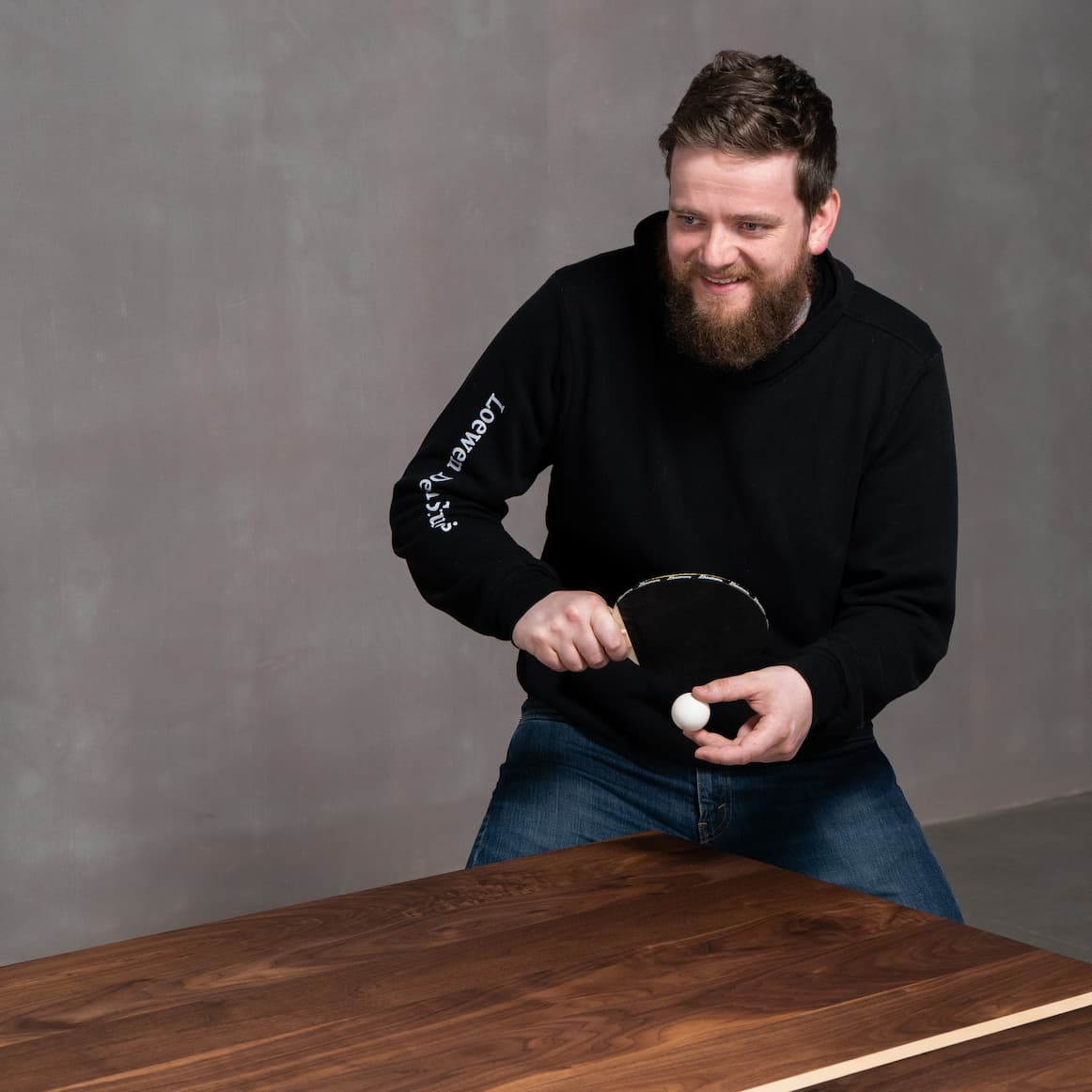 person playing ping pong on a custom walnut ping pong table 
