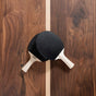 center line detail of a custom walnut ping pong table with paddles 