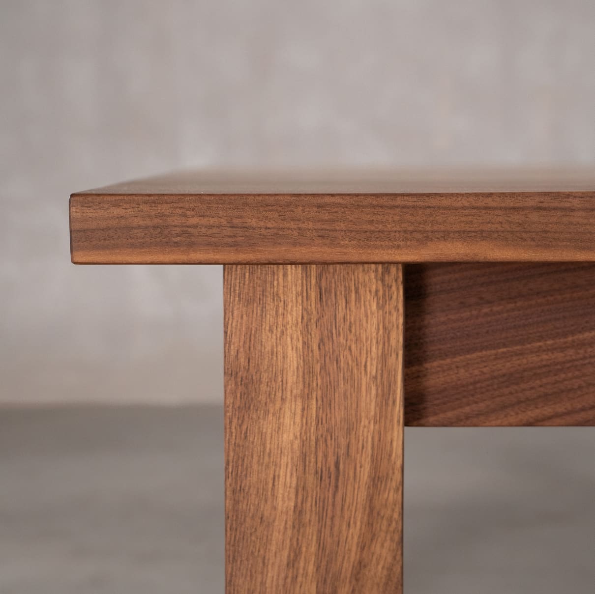 edge detail of a custom walnut ping pong table with net and paddles 
